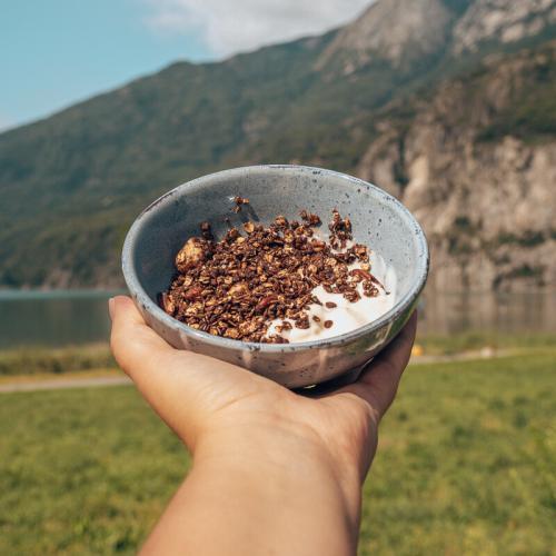 Knapperige chocolademuesli met yoghurt in kom voor berg en meer.