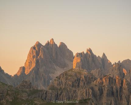 Zonsopgang boven de bergtoppen, oranje kleuren en stekelige toppen bij Rifugio Auronzo