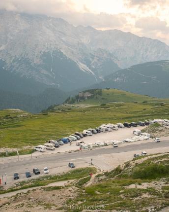 Uitzicht van bovenaf op de Rifugio Auronzo-nachtparkeerplaats voor campers. de vallei en de bergen aan de achterkant.